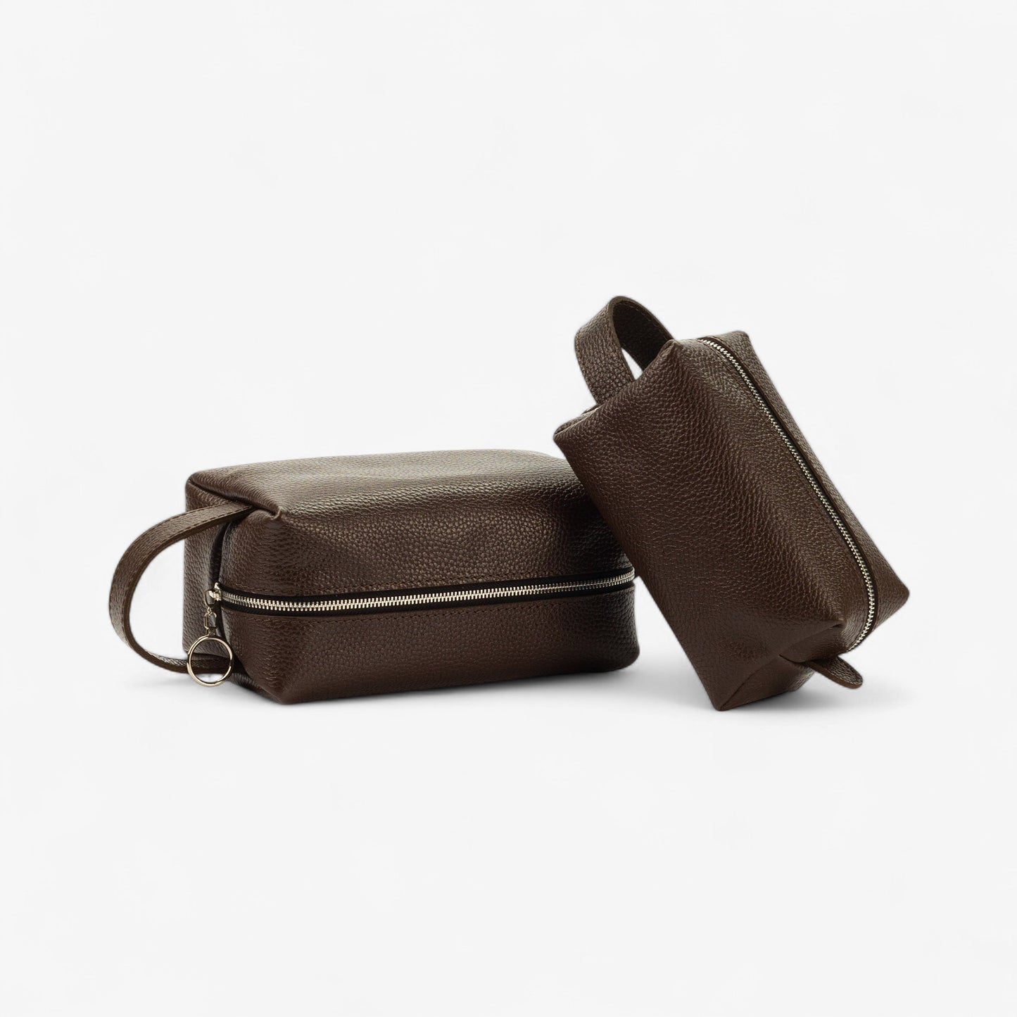 Two brown leather toiletry bags on a white background