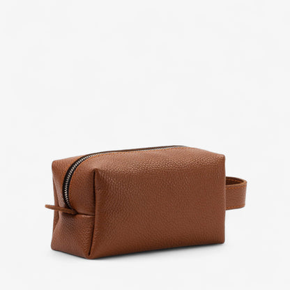 Brown leather toiletry bag with a zipper on a white background