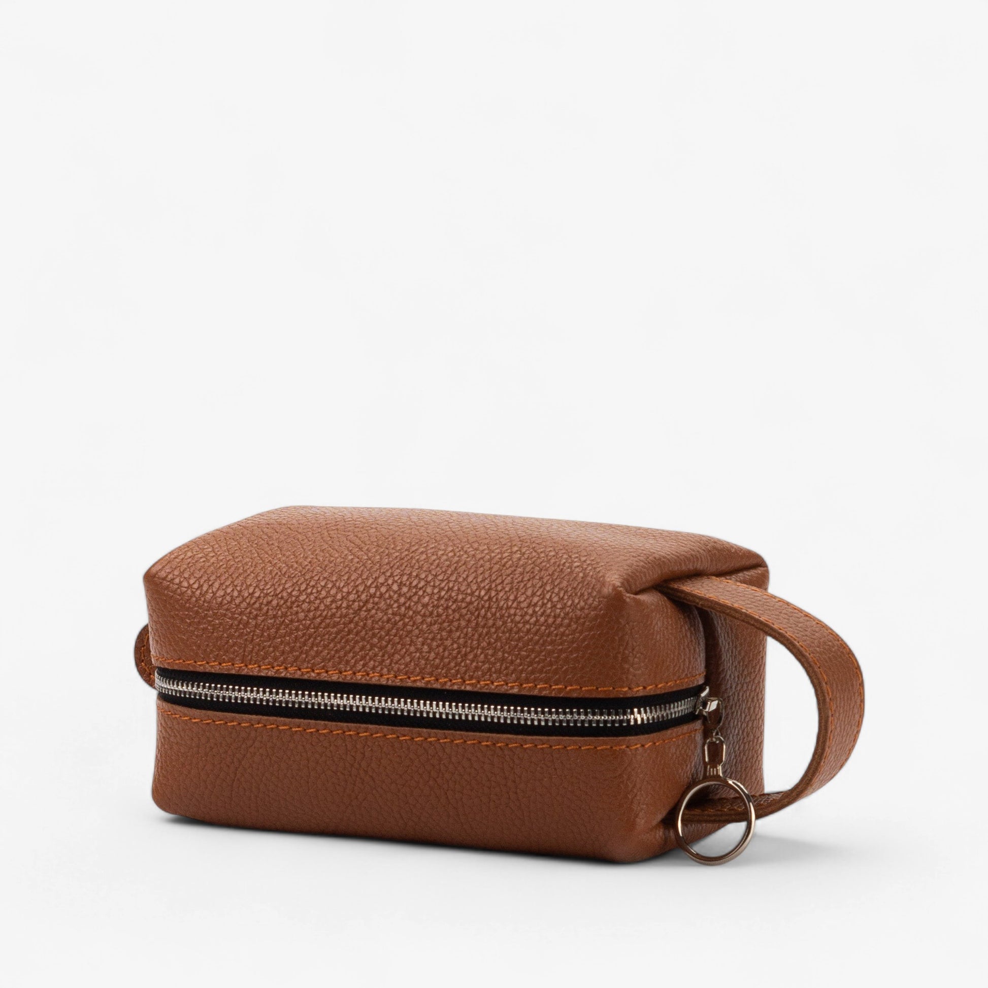 Brown leather toiletry bag with a handle on a white background