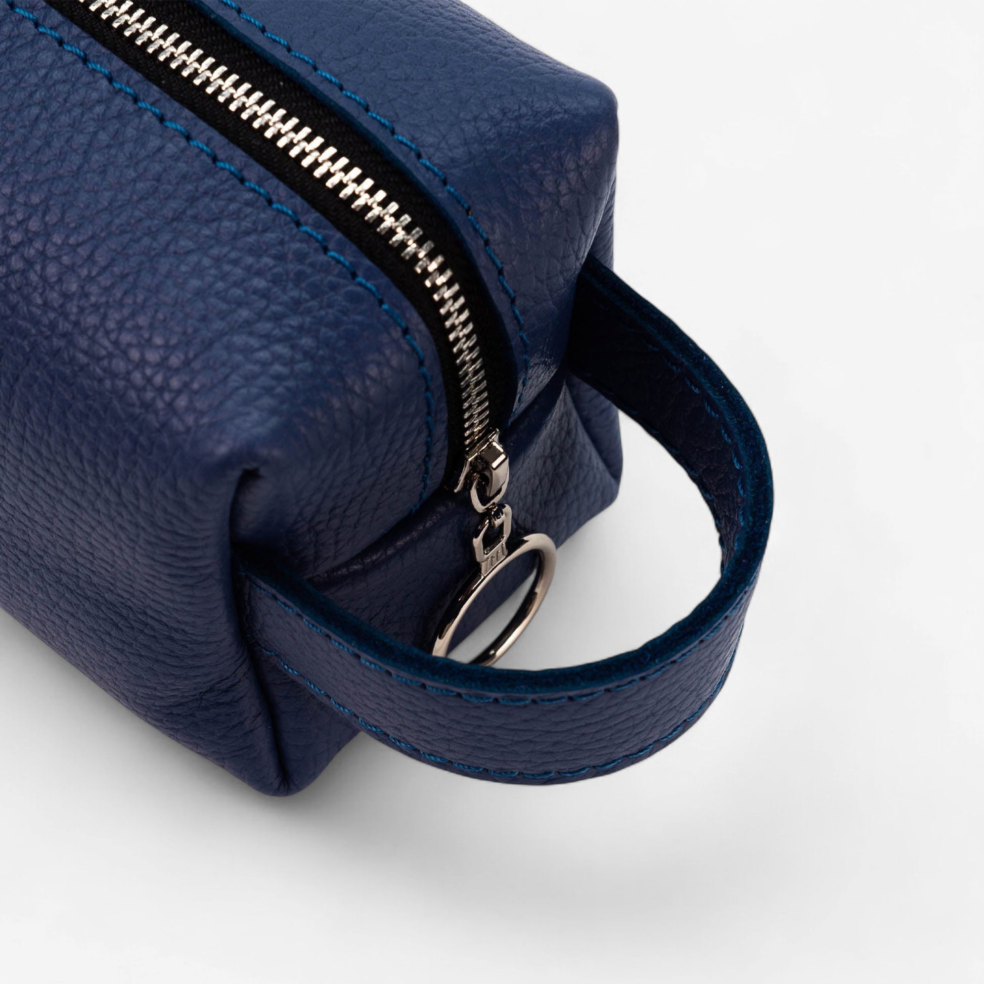 Navy blue leather bag with a zipper on a white background