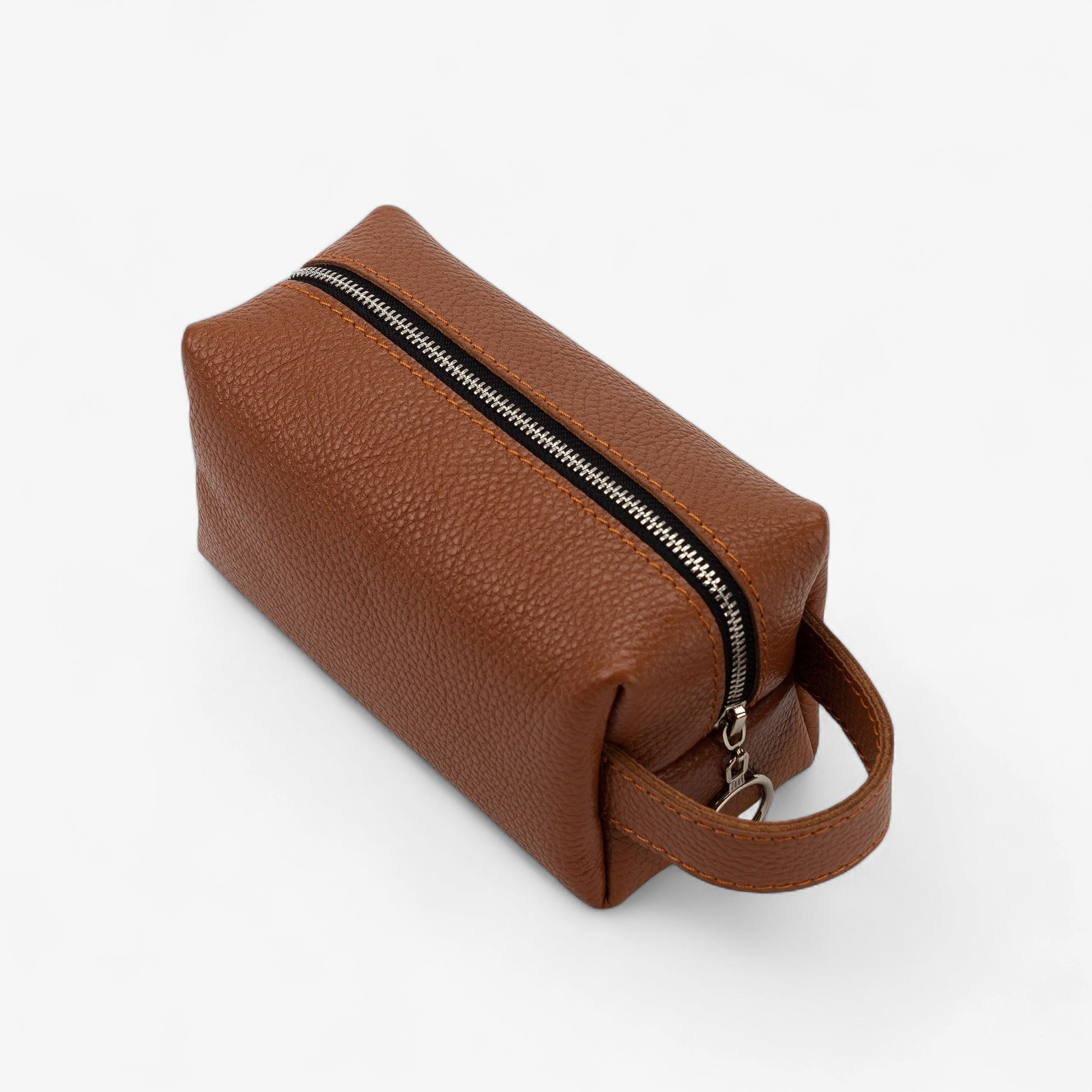 Brown leather toiletry bag with a zipper on a white background