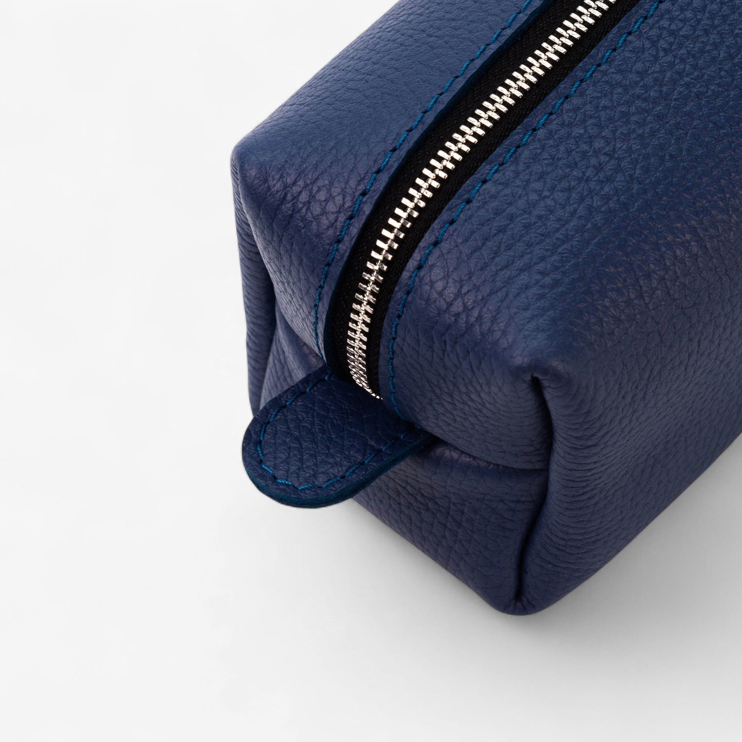 Blue leather dopp kit with zipper on a white background