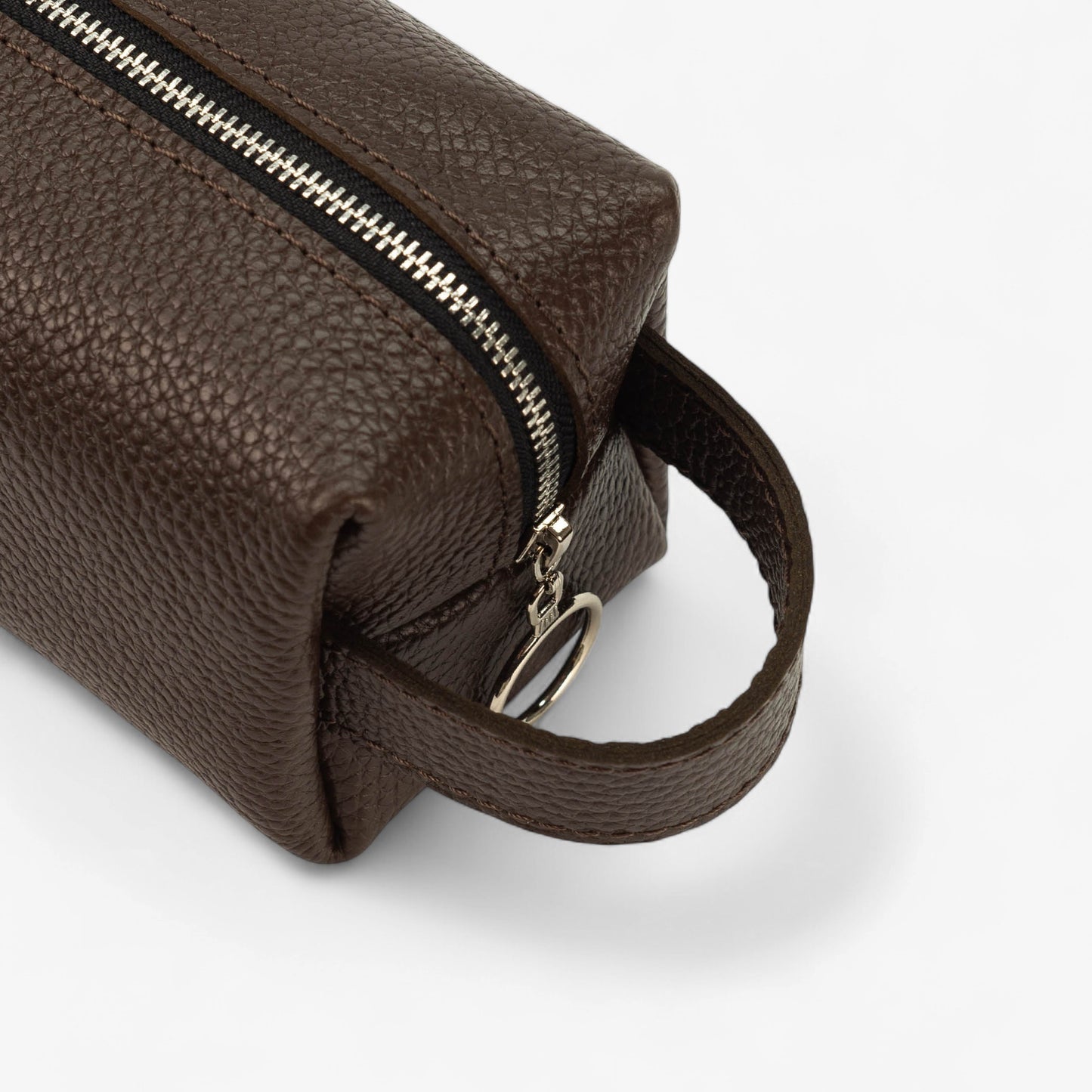 Brown leather toiletry bag with a zipper on a white background