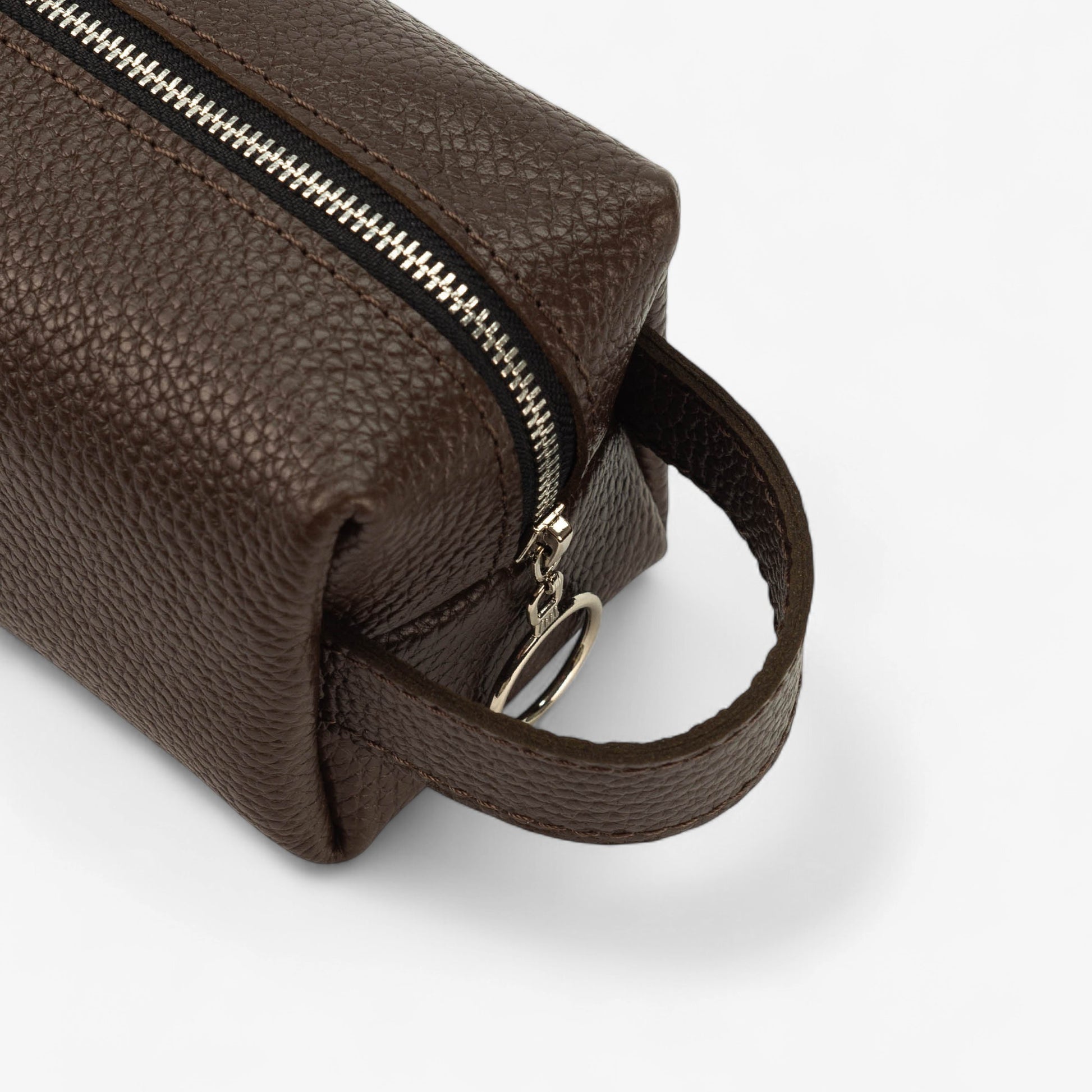 Brown leather toiletry bag with a zipper on a white background