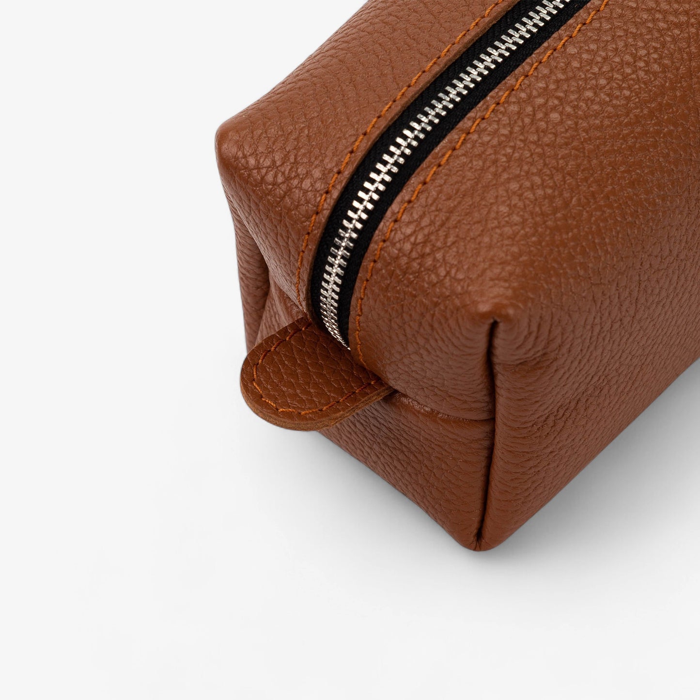 Brown leather toiletry bag with a zipper on a white background
