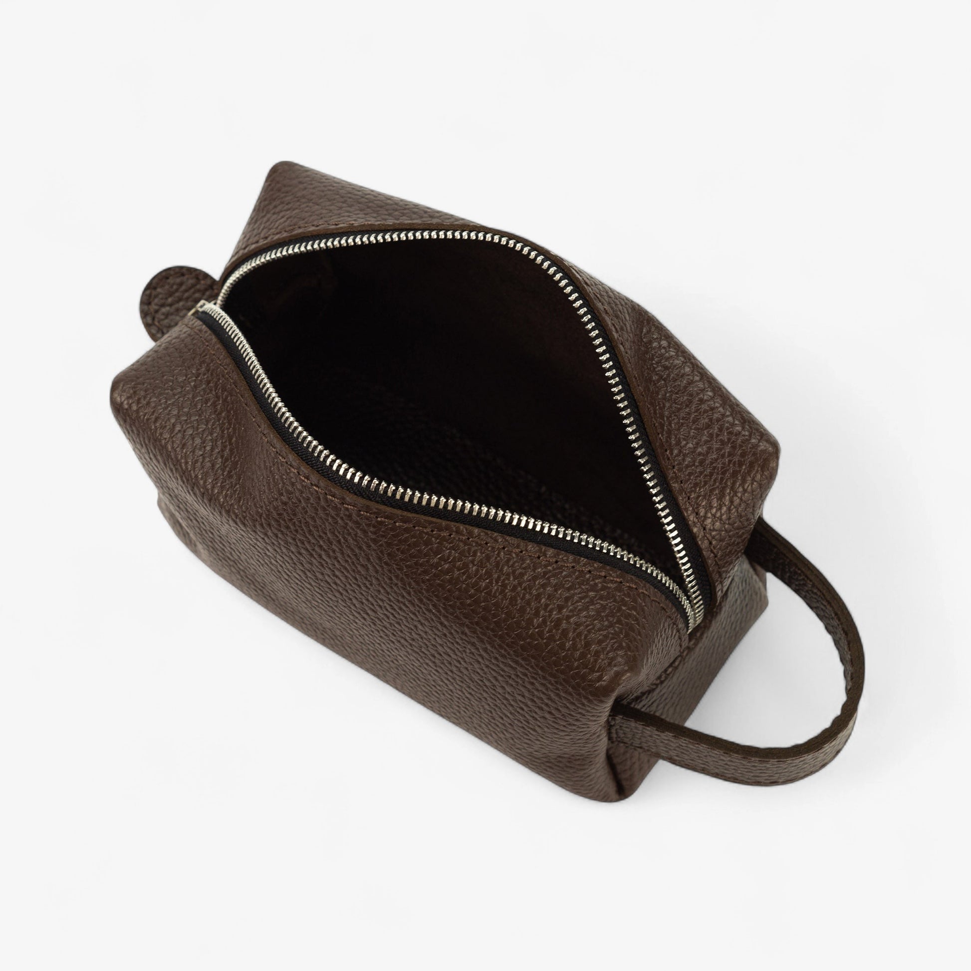 Brown leather dopp kit with open zipper on a white background