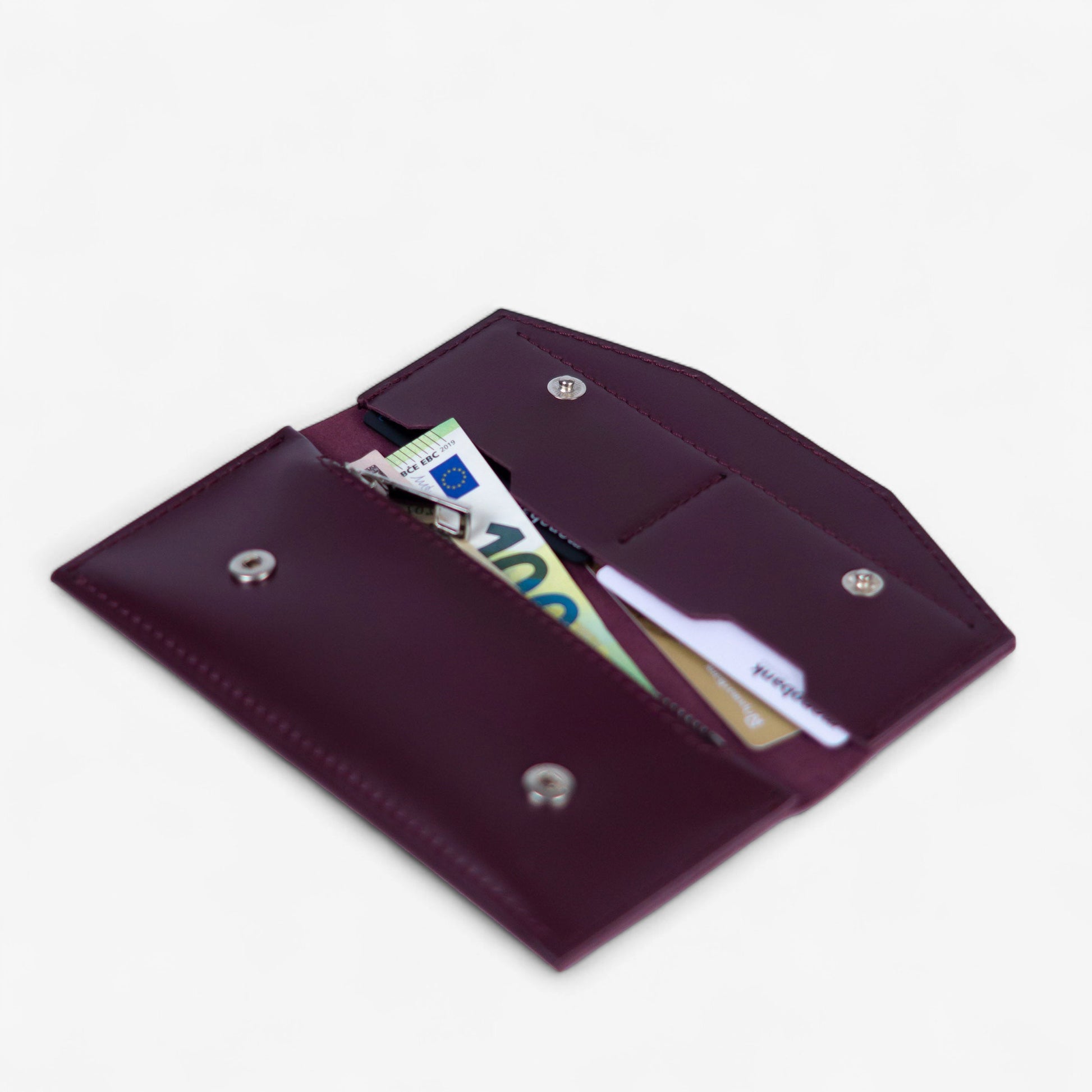 Open burgundy leather wallet filled with cards and cash, compact everyday design