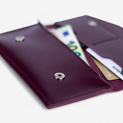 Open burgundy handmade leather wallet, empty interior with card slots and compartments
