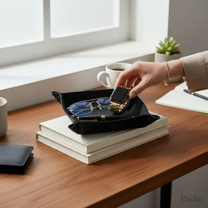Pache black leather desk catchall tray holding glasses, pen, and a gold smartwatch.