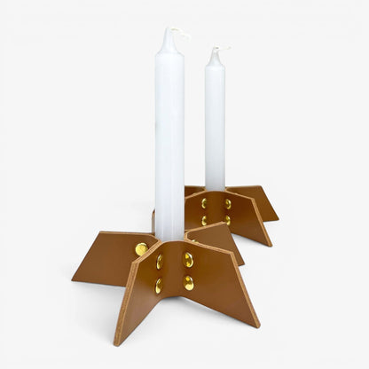 Pache brown leather candle holder set, minimalist design with gold rivets, holding white taper candles.