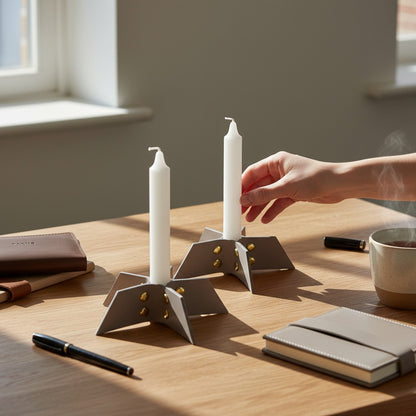Pache gray leather candle holder set with gold rivets, minimalist design, holding white taper candles.