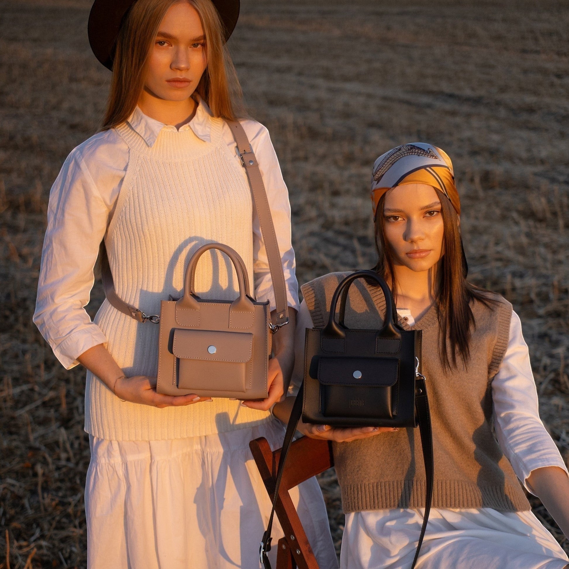 Pache gray mini tote bag made of smooth leather with a front pocket and adjustable strap, held by a woman.